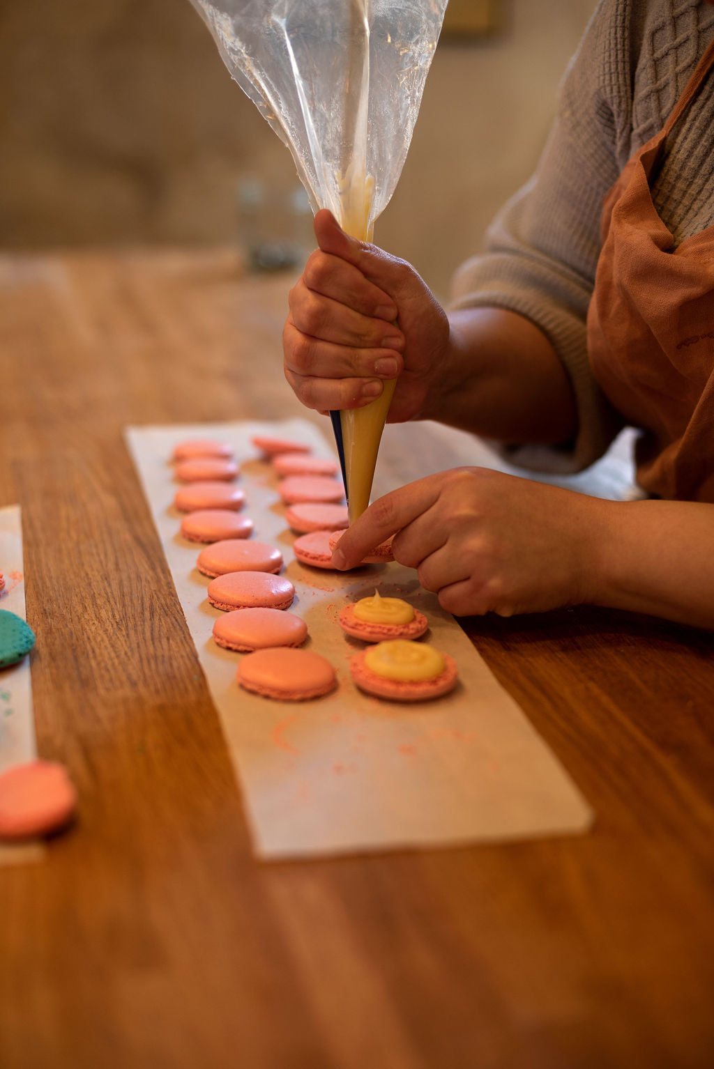 Piping macaron shells onto a baking sheet during a small group macaron class at Maison Fleuret