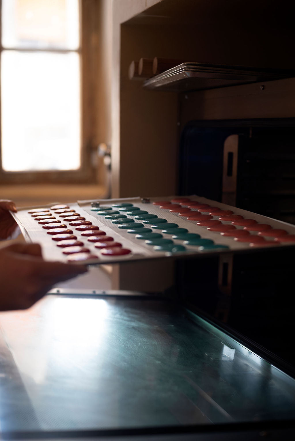 Interior of Maison Fleuret's intimate baking studio with macarons cooling near a sunlit window